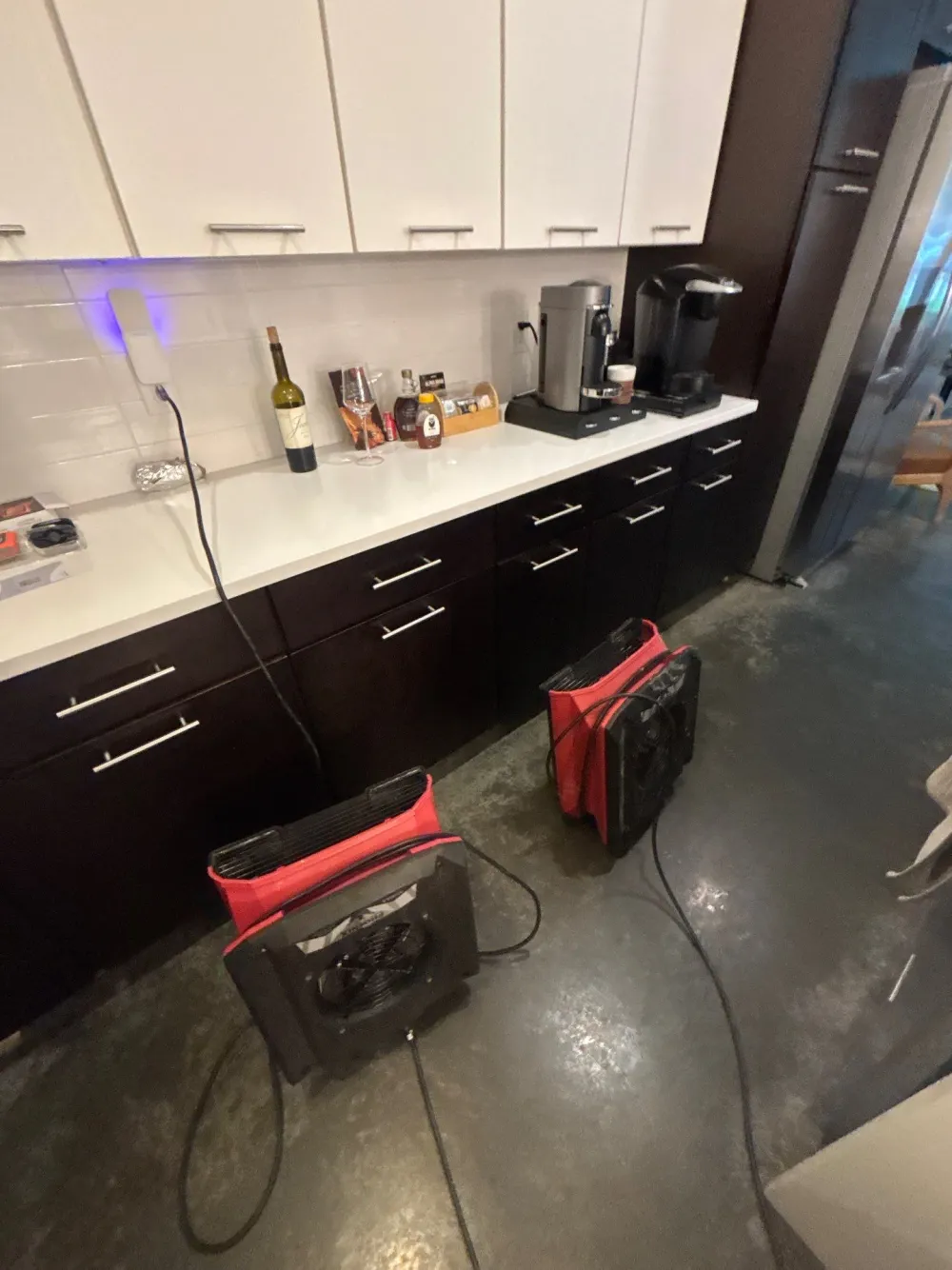 Commercial air movers running on a wet floor during a Nashville water mitigation and structural drying job